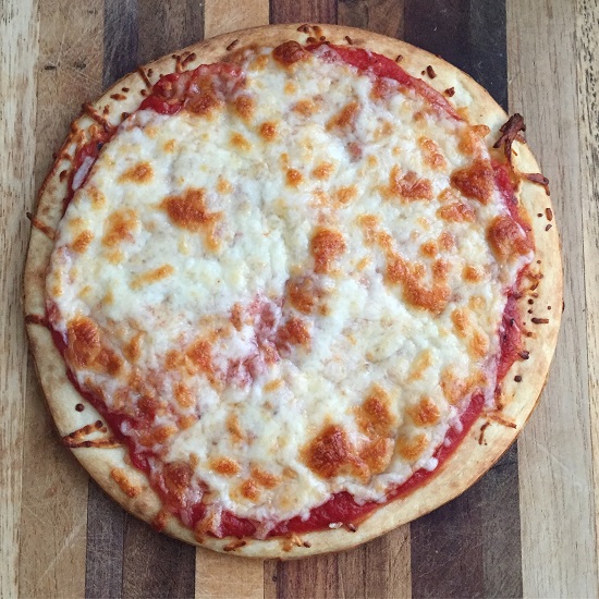 Small pizza with red sauce and cheese, on top of wooden cutting board