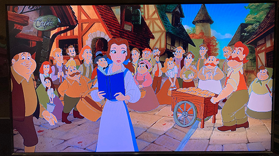 screenshot of Belle in village, holding book and basket while villagers look at her in the background