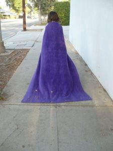 Small girl in purple cloak walking away