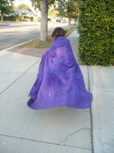 Small girl in purple cloak running