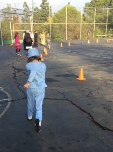 Small girl in scrubs costume running