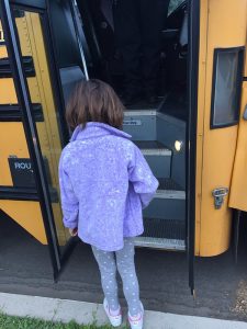 little girl boarding school bus